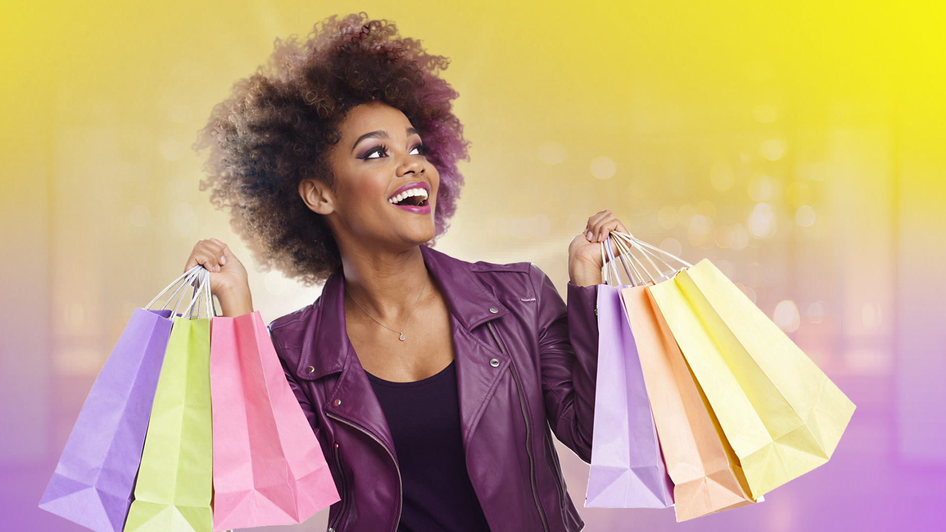 Eine junge Frau mit Locken als Shopperin mit Taschen